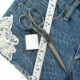 Jeans tagliato, forbice, pizzo, ago e filo