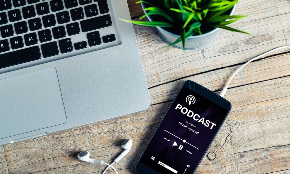 computer, smartphone e cuffiette per ascoltare un podcast