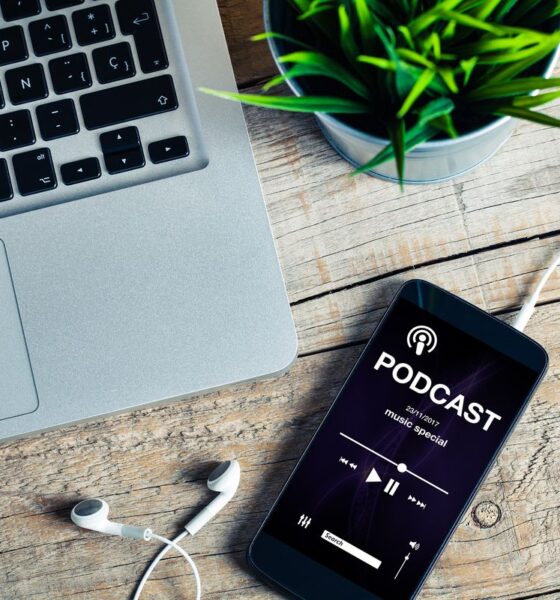 computer, smartphone e cuffiette per ascoltare un podcast