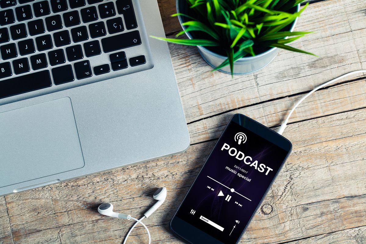 computer, smartphone e cuffiette per ascoltare un podcast